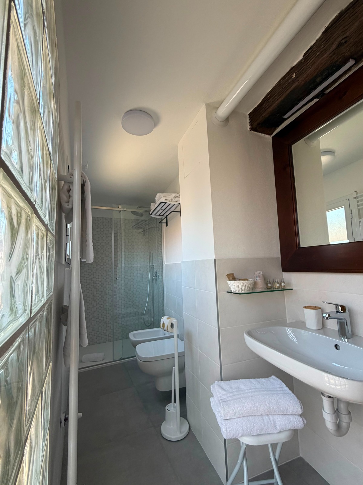 Bagno con doccia, lavabo e biancheria